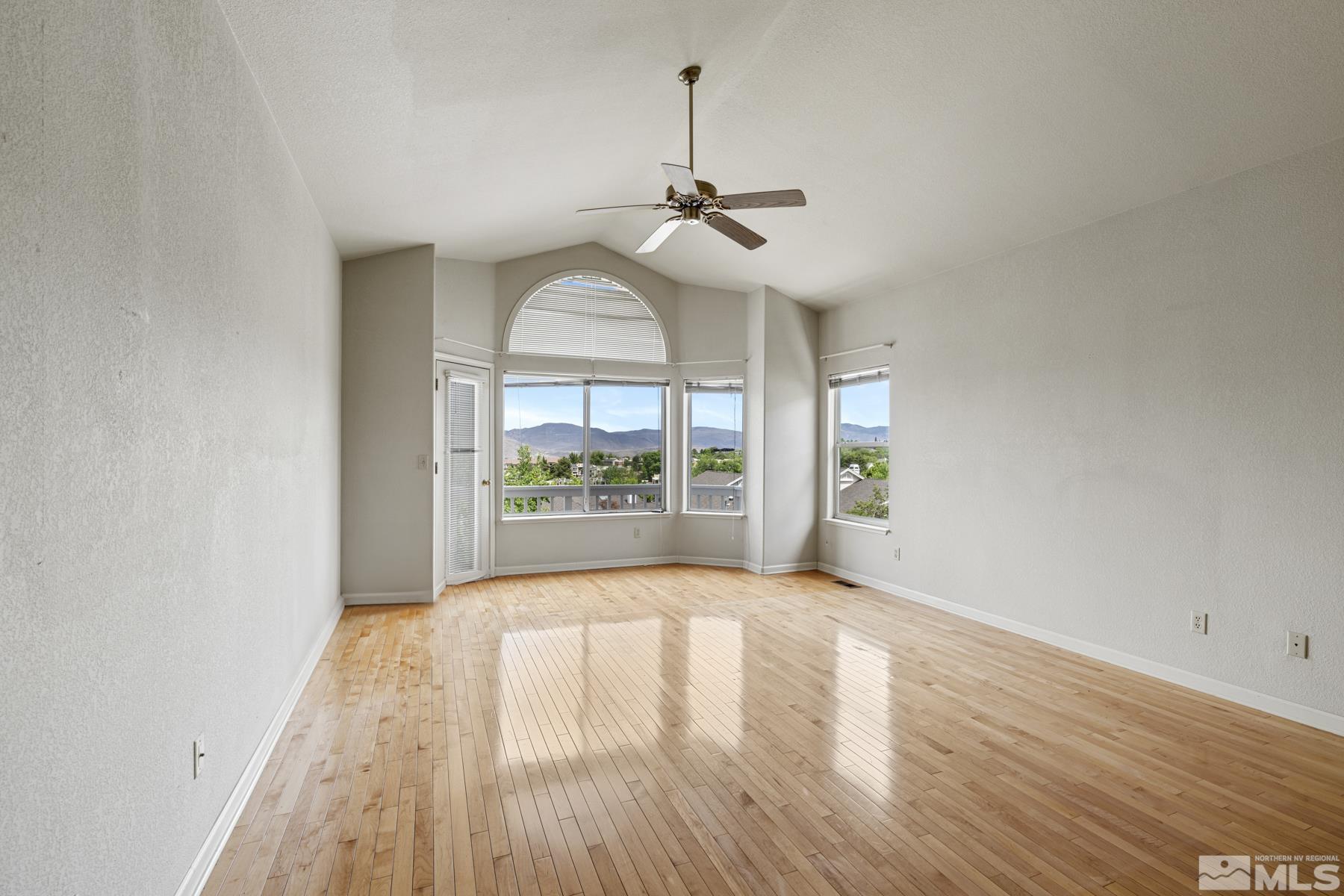 6172 Squires Lane Reno, NV 89519 - Photo 22 of 40 a view of empty room with wooden floor and fan