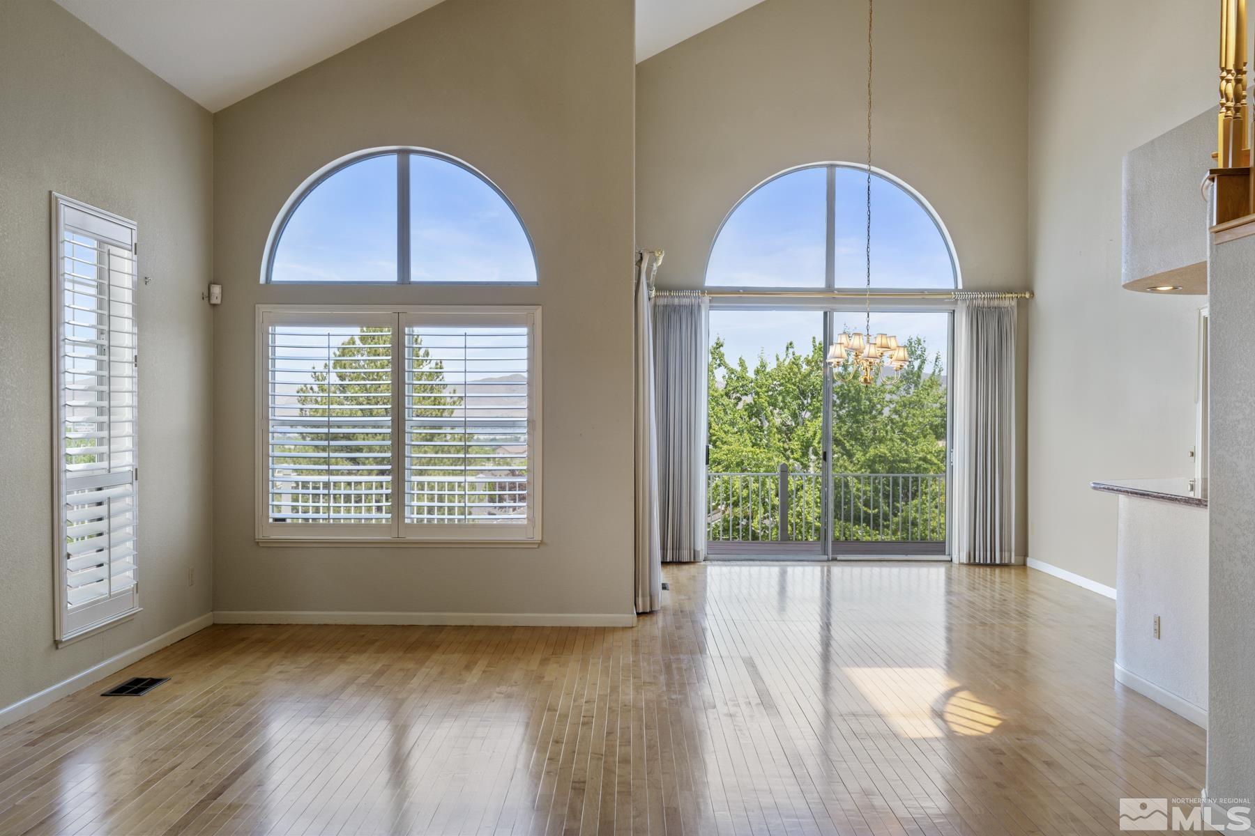 6172 Squires Lane Reno, NV 89519 - Photo 7 of 40 a view of an empty room with wooden floor and a window