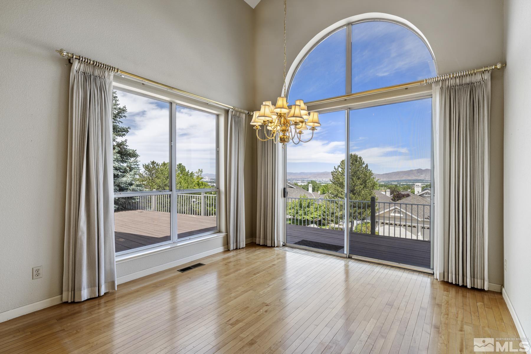 6172 Squires Lane Reno, NV 89519 - Photo 8 of 40 a view of an empty room with wooden floor and a window