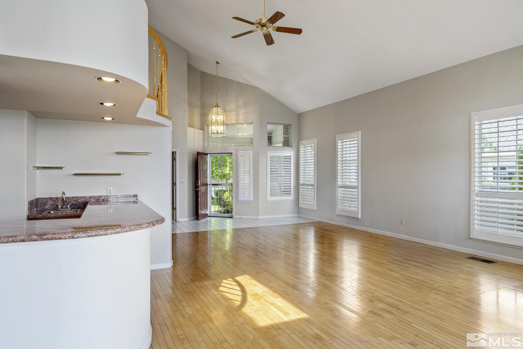 6172 Squires Lane Reno, NV 89519 - Photo 9 of 40 a living room with hard wood floors and a kitchen