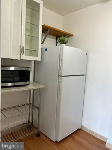 a white refrigerator freezer and a stove sitting inside of a kitchen