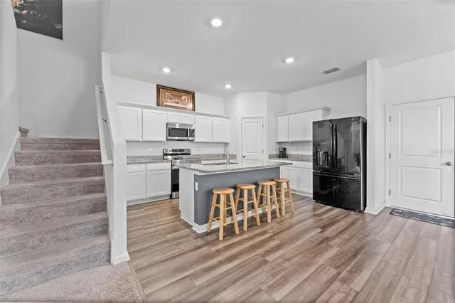 a kitchen with a refrigerator and a stove top oven