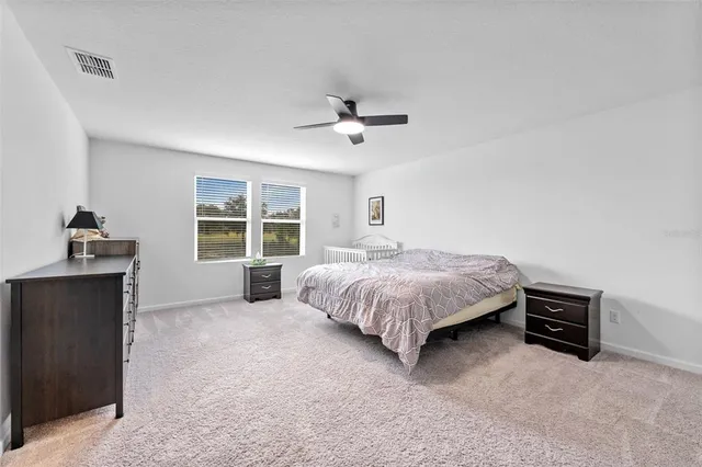 a spacious bedroom with a bed and a window