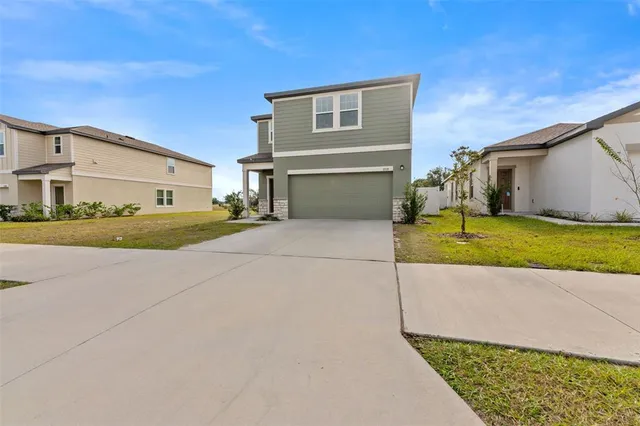 a view of a house with a yard and garage