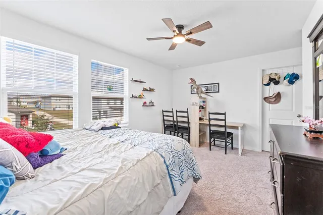a bedroom with a bed desk and a window