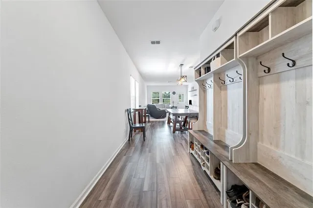 a view of a hallway with wooden floor and staircase