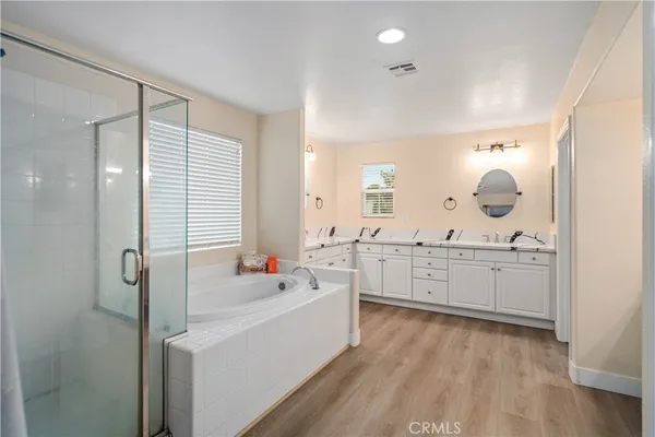 a large bathroom with a double vanity sink a mirror and a bathtub