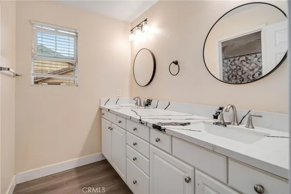 a bathroom with a granite countertop double vanity sink and a mirror