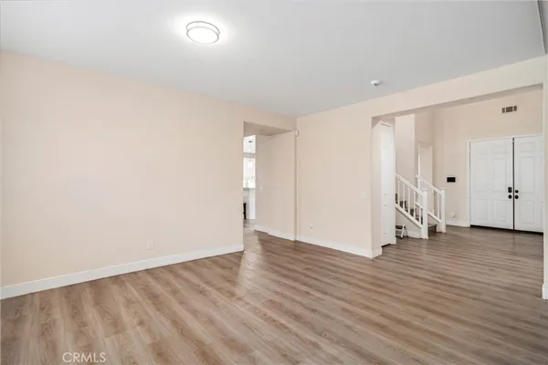 a view of an empty room with wooden floor