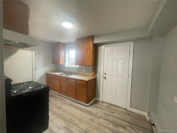 a room with kitchen island stainless steel appliances a sink stove and refrigerator