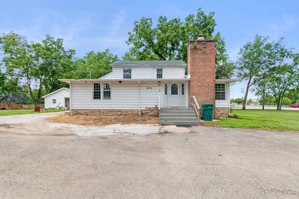 front view of house with a yard and potted plants