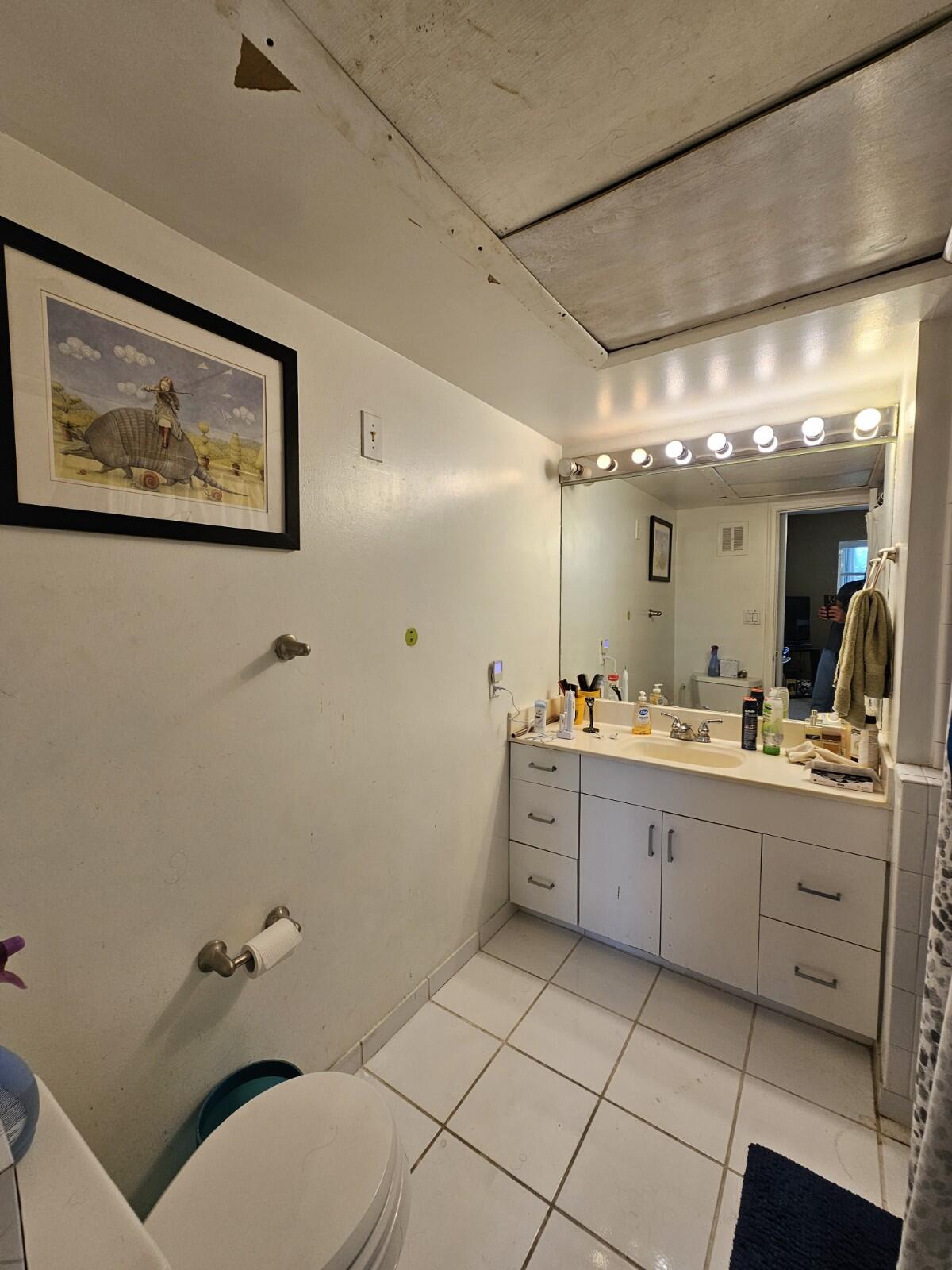 119 Northeast 19th Court, Unit 211G Wilton Manors, FL 33305 - Photo 12 of 21 a bathroom with a granite countertop sink mirror vanity and toilet