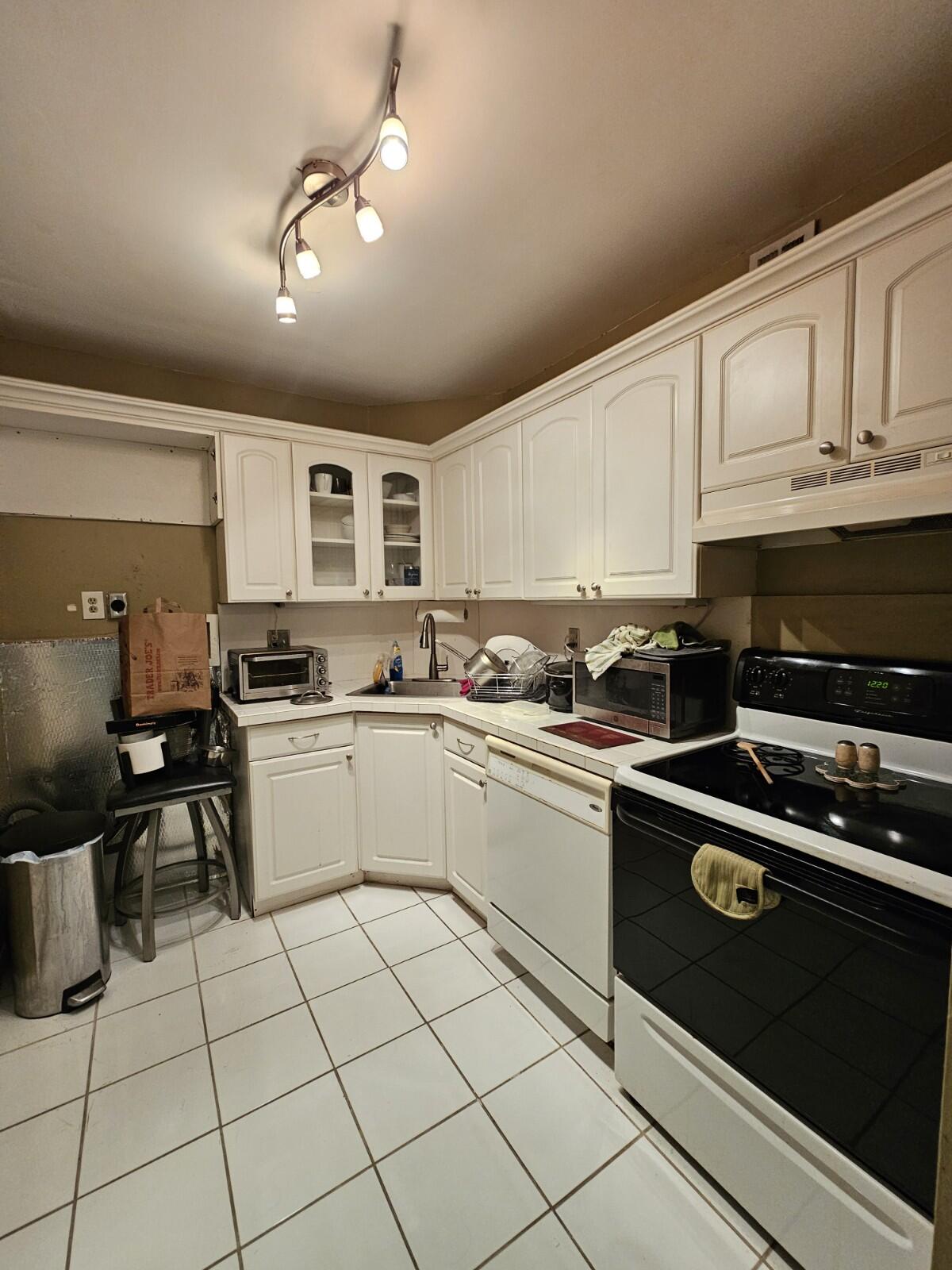 119 Northeast 19th Court, Unit 211G Wilton Manors, FL 33305 - Photo 15 of 21 a kitchen with granite countertop a sink window and cabinets
