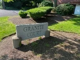 a sign that is sitting in the middle of garden