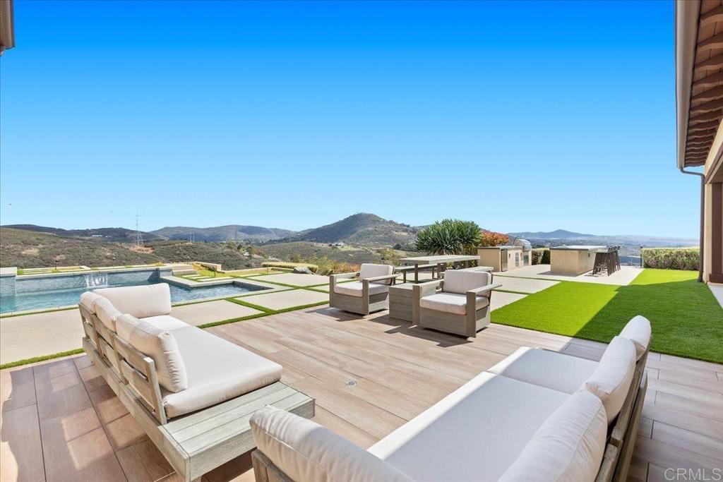 3849 Rancho Summit Drive Encinitas, CA 92024 - Photo 52 of 63 a view of a patio with couches and table and chairs under an umbrella
