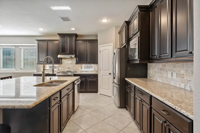 a kitchen with stainless steel appliances granite countertop a sink stove and refrigerator