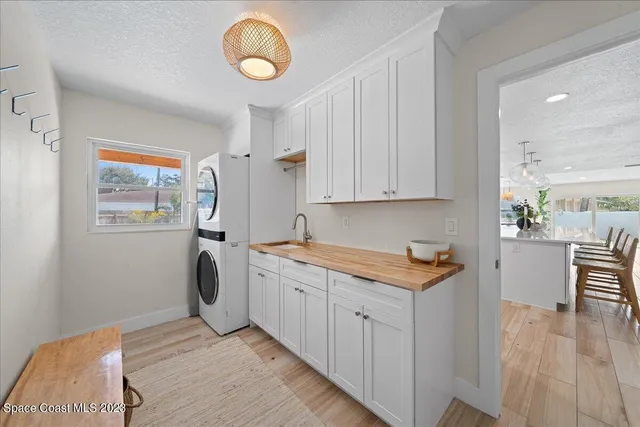 a bedroom with a bed a chair and potted plant on the dresser
