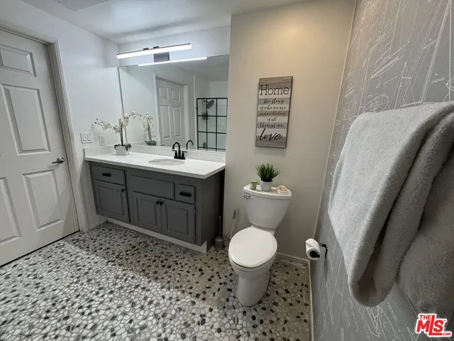 a bathroom with a sink toilet vanity and shower