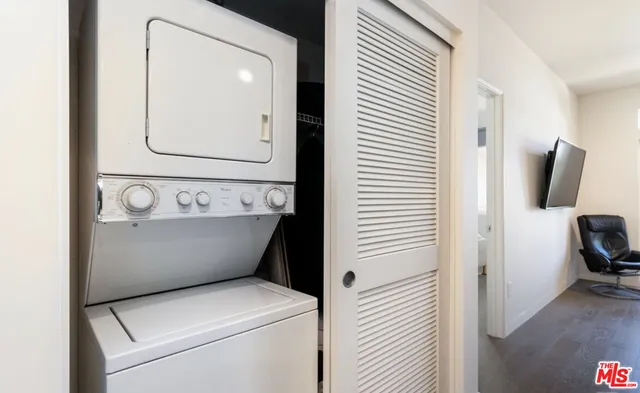 a view of washer and dryer with bathroom in the background