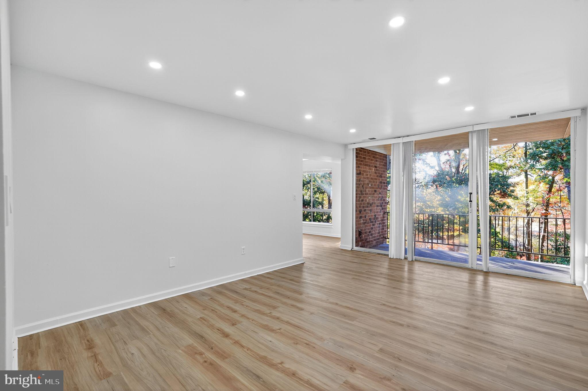 8481 Greenbelt Road, Unit 201 Greenbelt, MD 20770 - Photo 11 of 26 a view of an empty room with wooden floor and a window