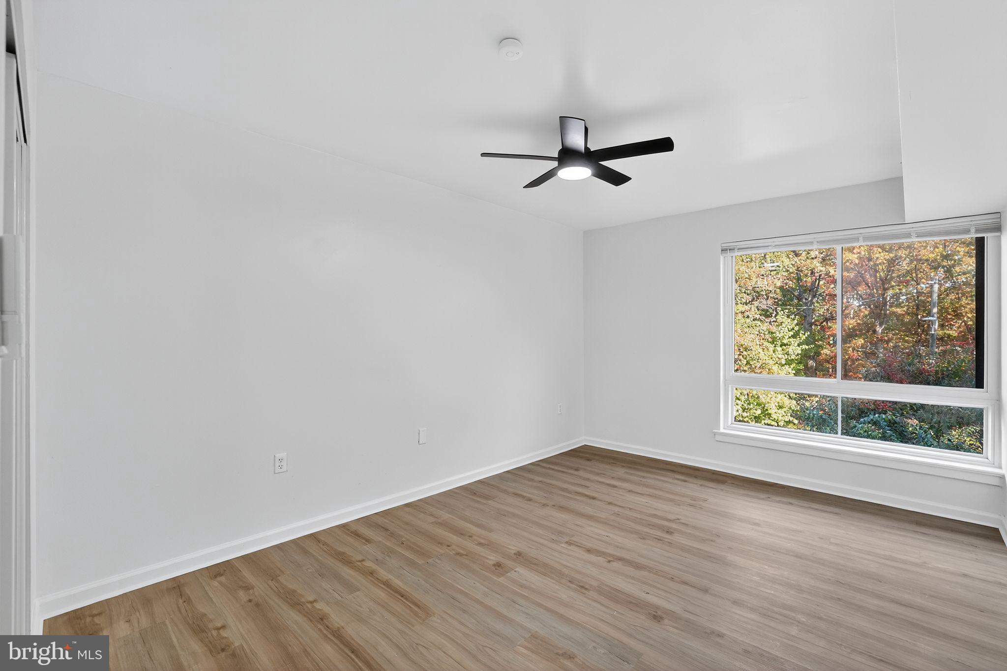 8481 Greenbelt Road, Unit 201 Greenbelt, MD 20770 - Photo 13 of 26 wooden floor in an empty room with a window
