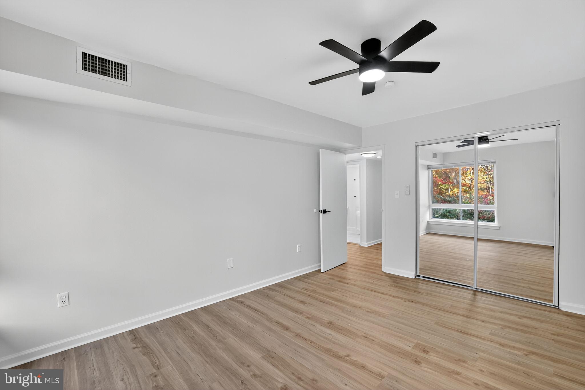 8481 Greenbelt Road, Unit 201 Greenbelt, MD 20770 - Photo 14 of 26 an empty room with wooden floor and windows