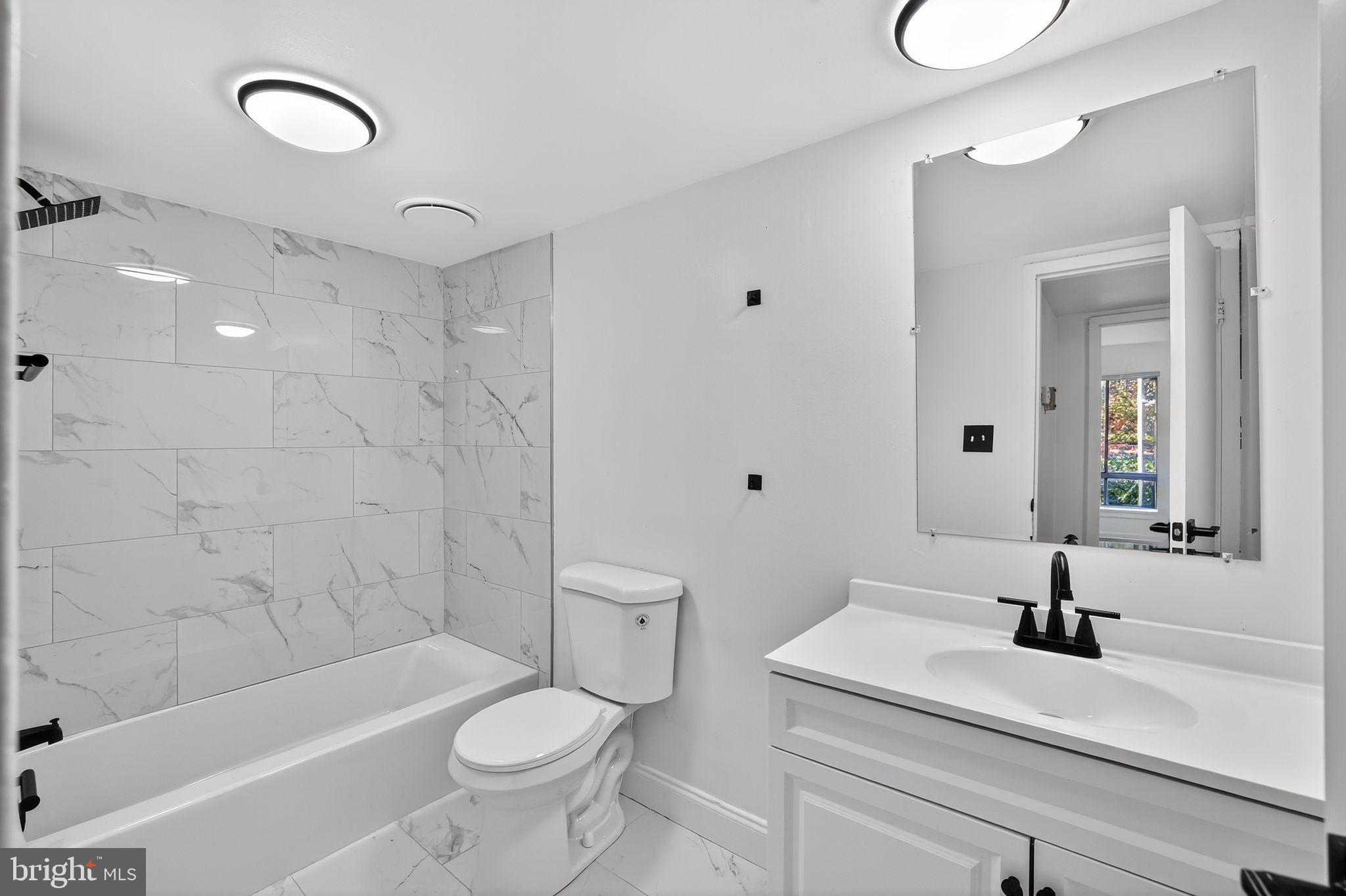 8481 Greenbelt Road, Unit 201 Greenbelt, MD 20770 - Photo 17 of 26 a bathroom with a sink a toilet and shower