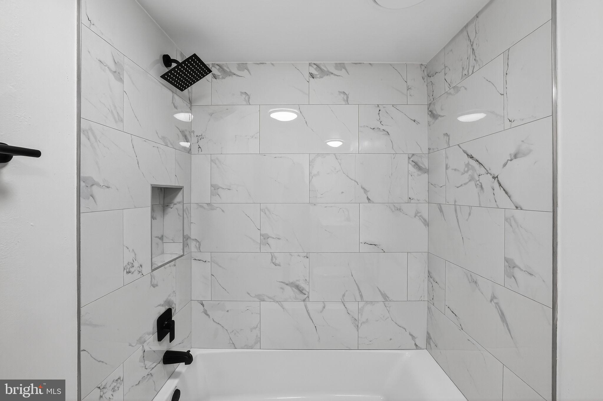 8481 Greenbelt Road, Unit 201 Greenbelt, MD 20770 - Photo 18 of 26 a bathroom with a bathtub and shower