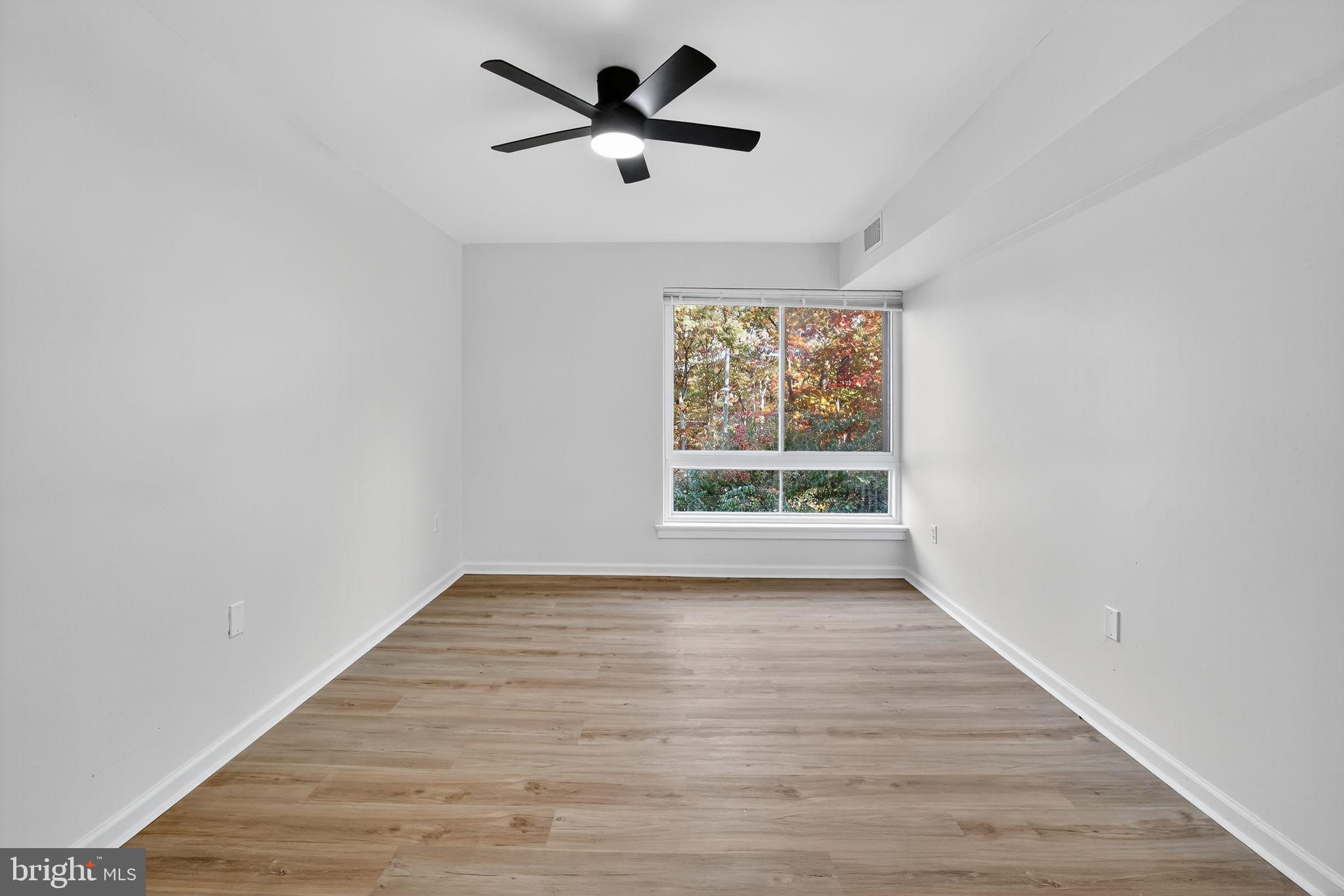 8481 Greenbelt Road, Unit 201 Greenbelt, MD 20770 - Photo 19 of 26 an empty room with wooden floor and windows