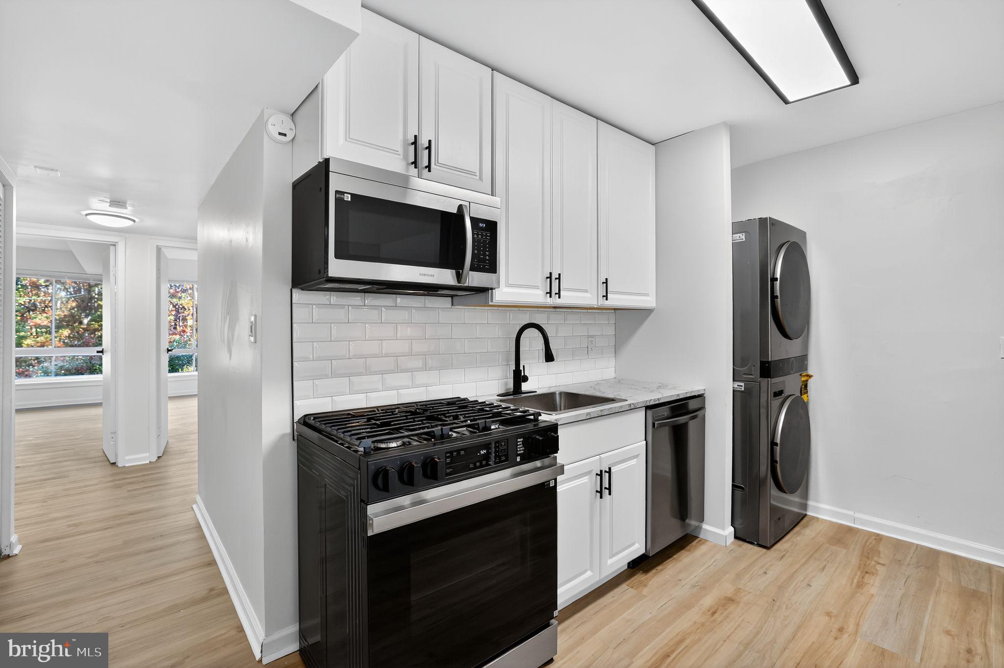 8481 Greenbelt Road, Unit 201 Greenbelt, MD 20770 - Photo 5 of 26 a kitchen with stainless steel appliances granite countertop a stove a refrigerator and a microwave
