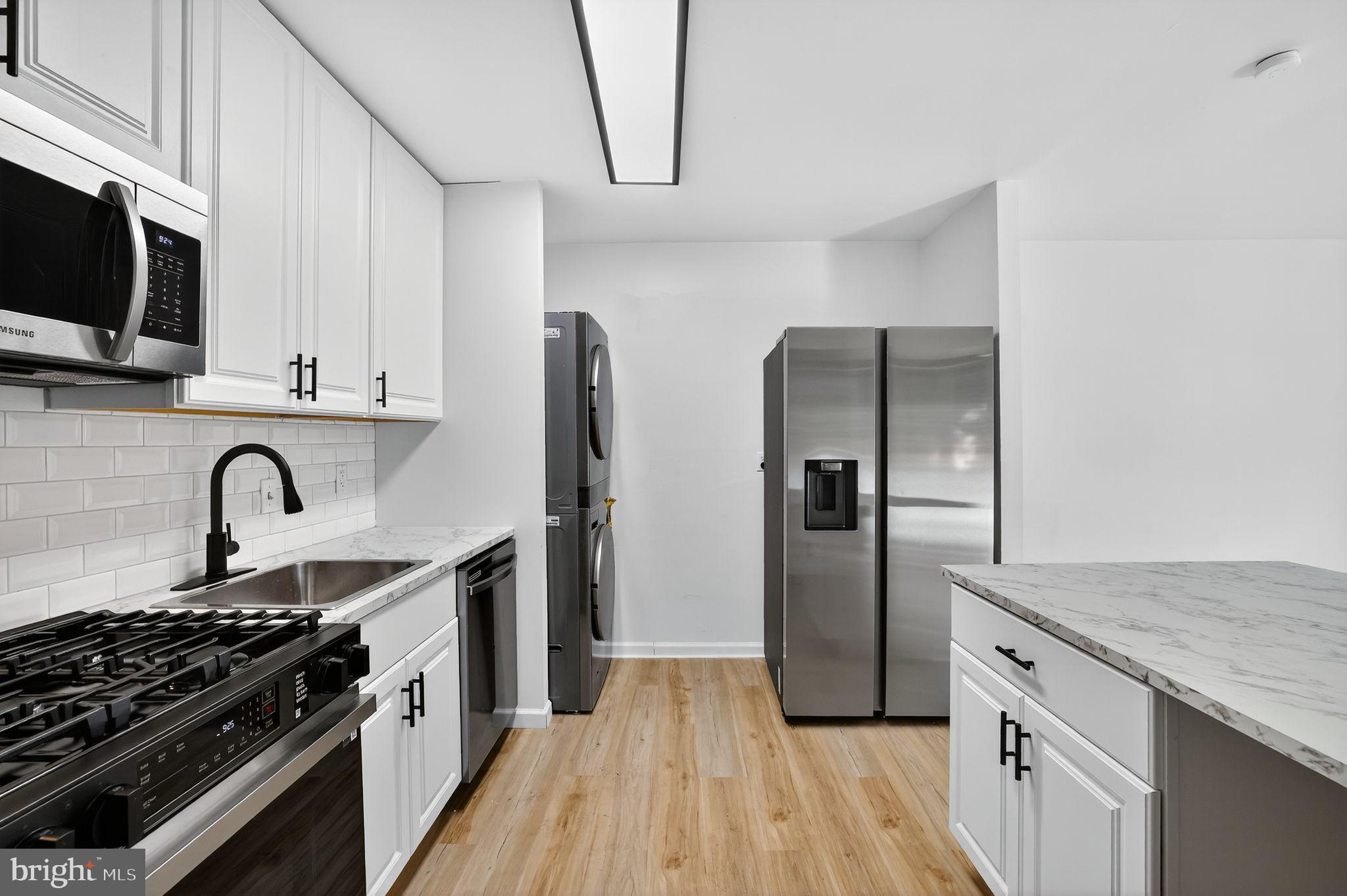 8481 Greenbelt Road, Unit 201 Greenbelt, MD 20770 - Photo 7 of 26 a kitchen with stainless steel appliances granite countertop a stove and a refrigerator
