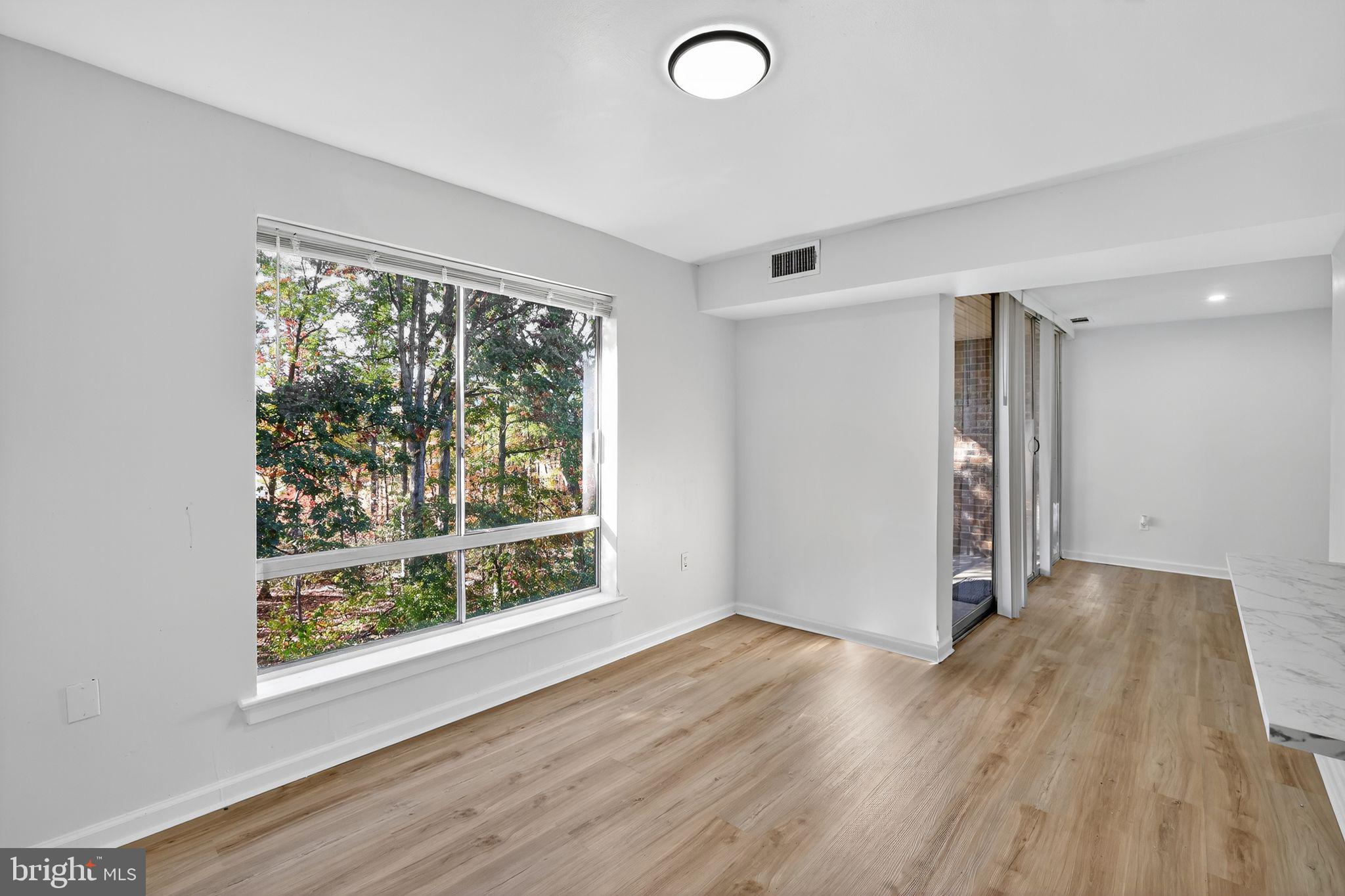 8481 Greenbelt Road, Unit 201 Greenbelt, MD 20770 - Photo 10 of 26 an empty room with wooden floor and windows