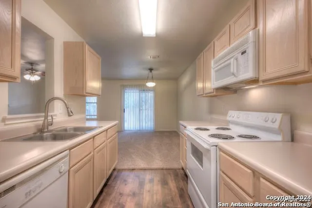 an empty room with windows and chandelier fan