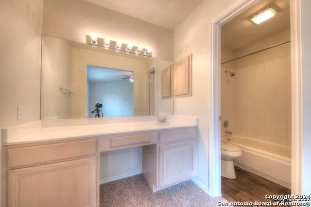 a view of a house with a large tree and wooden fence