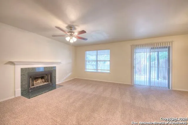a view of an empty room with window and a fireplace