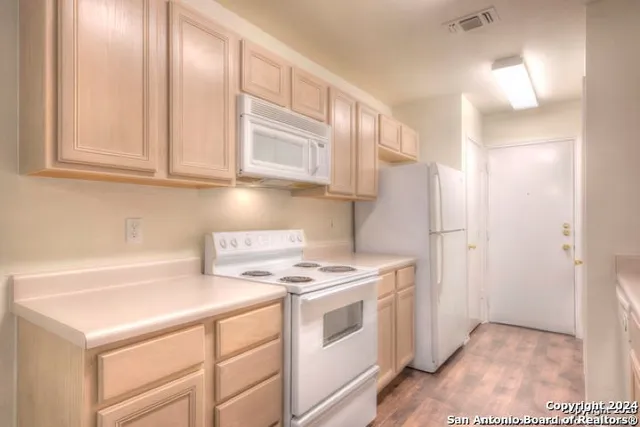 a kitchen with cabinets and white appliances