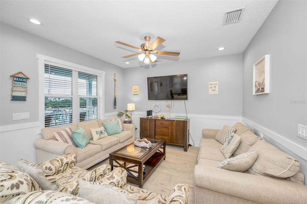204 Gulf Boulevard Indian Rocks Beach, FL 33785 - Photo 16 of 72 a living room with furniture and a flat screen tv