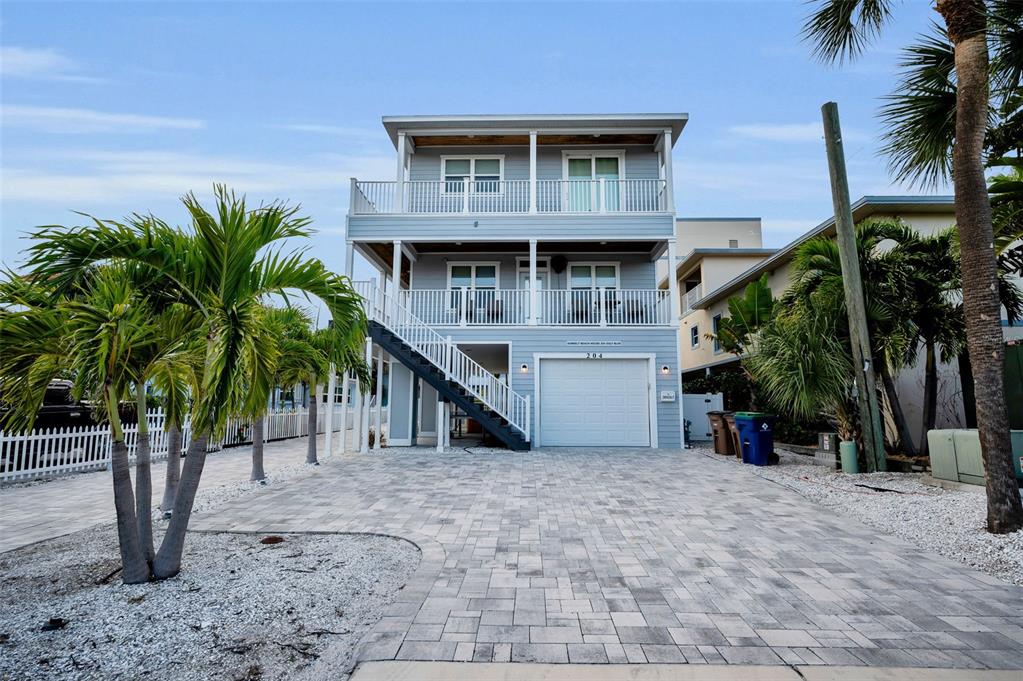 204 Gulf Boulevard Indian Rocks Beach, FL 33785 - Photo 2 of 72 a view of a house with a small yard and palm trees