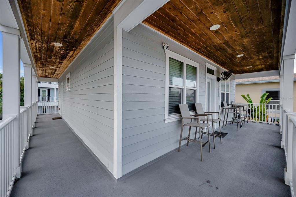 204 Gulf Boulevard Indian Rocks Beach, FL 33785 - Photo 22 of 72 a view of a porch with chairs and table in a patio
