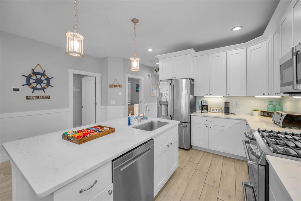 204 Gulf Boulevard Indian Rocks Beach, FL 33785 - Photo 30 of 72 a kitchen with refrigerator a sink and cabinets