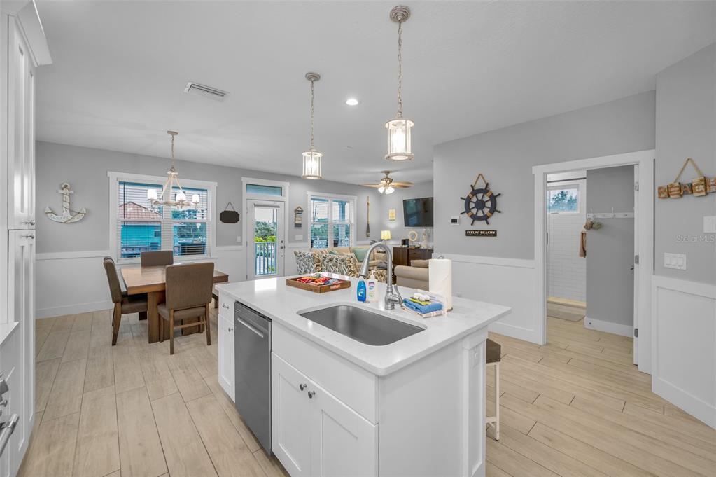 204 Gulf Boulevard Indian Rocks Beach, FL 33785 - Photo 31 of 72 a kitchen with stainless steel appliances kitchen island a table chairs and a refrigerator