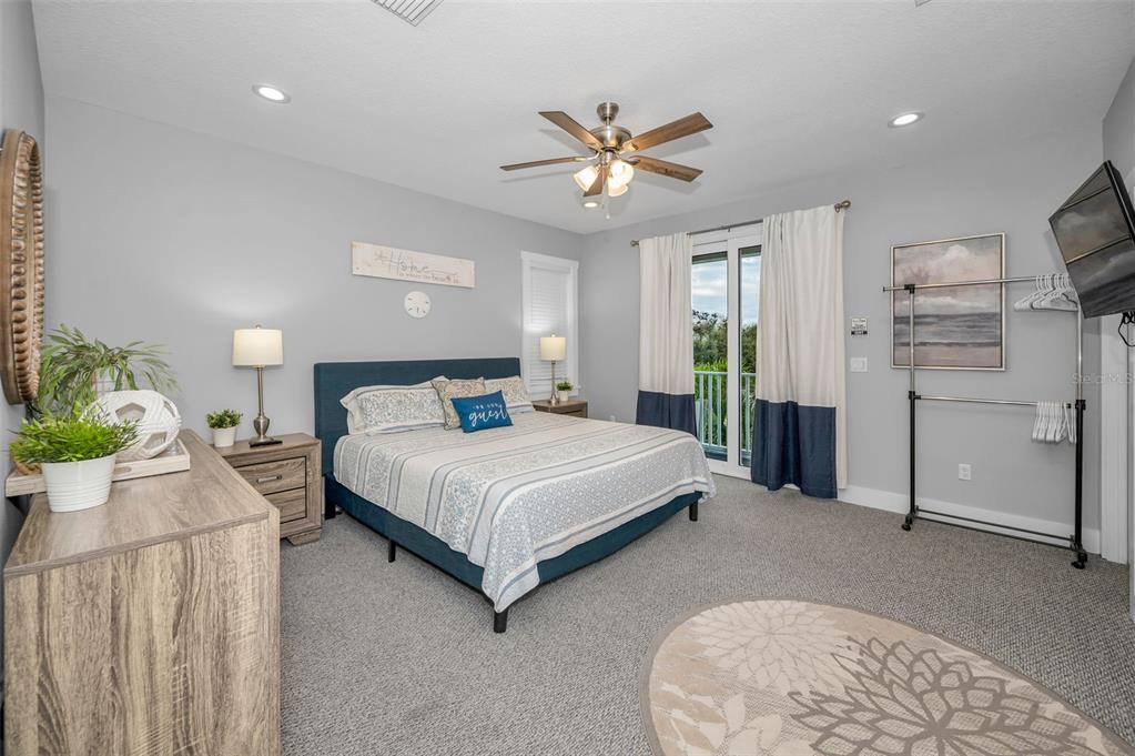 204 Gulf Boulevard Indian Rocks Beach, FL 33785 - Photo 38 of 72 a spacious bedroom with a bed and a chandelier