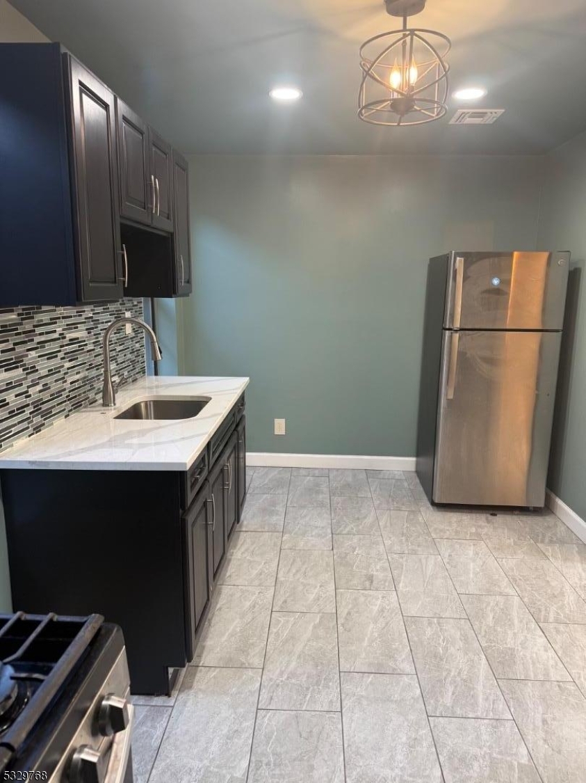 182 Ferry Street, Unit 2B Newark, NJ 07105 - Photo 13 of 16 a kitchen with a sink and a refrigerator