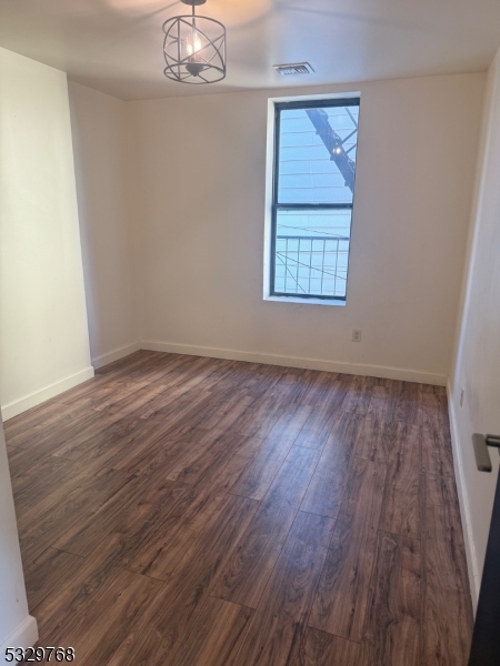 182 Ferry Street, Unit 2B Newark, NJ 07105 - Photo 3 of 16 a view of an empty room with wooden floor and a window
