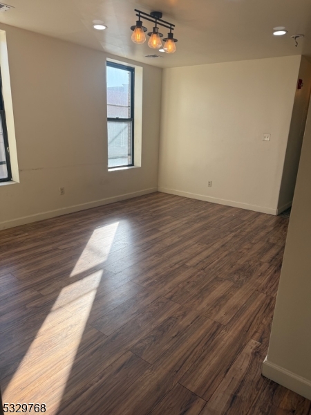 182 Ferry Street, Unit 2B Newark, NJ 07105 - Photo 4 of 16 an empty room with wooden floor and windows
