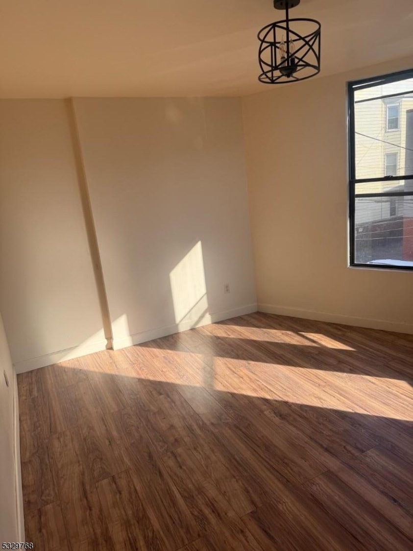 182 Ferry Street, Unit 2B Newark, NJ 07105 - Photo 6 of 16 a view of empty room with wooden floor and window