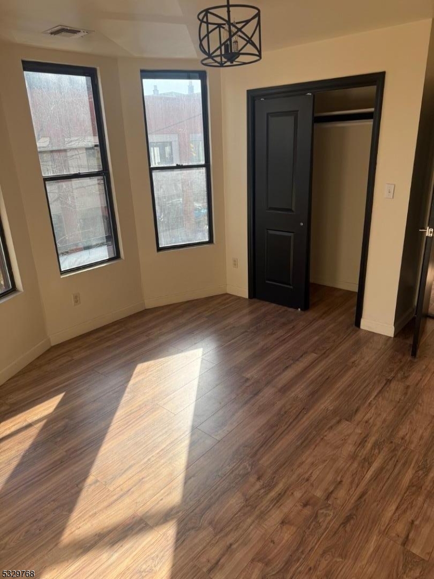 182 Ferry Street, Unit 2B Newark, NJ 07105 - Photo 7 of 16 a view of an empty room with wooden floor and a window