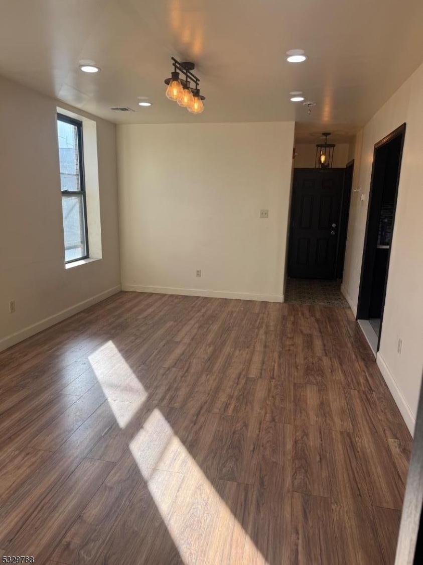 182 Ferry Street, Unit 2B Newark, NJ 07105 - Photo 8 of 16 an empty room with wooden floor and windows
