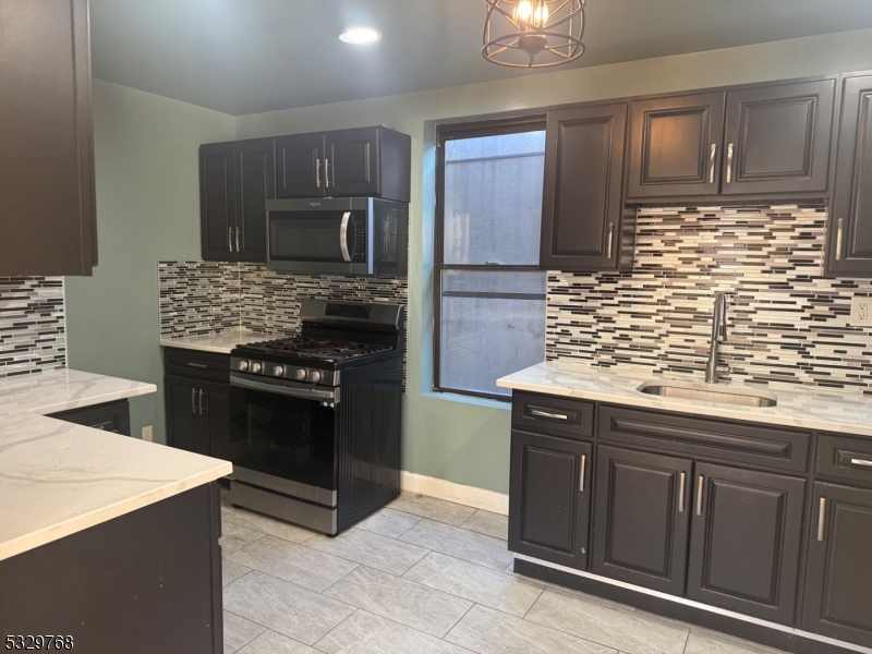 182 Ferry Street, Unit 2B Newark, NJ 07105 - Photo 9 of 16 a kitchen with stainless steel appliances granite countertop a stove and a refrigerator