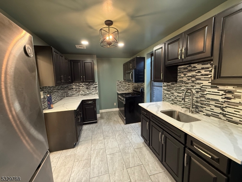 182 Ferry Street, Unit 2B Newark, NJ 07105 - Photo 10 of 16 a kitchen with stainless steel appliances granite countertop a sink stove and refrigerator